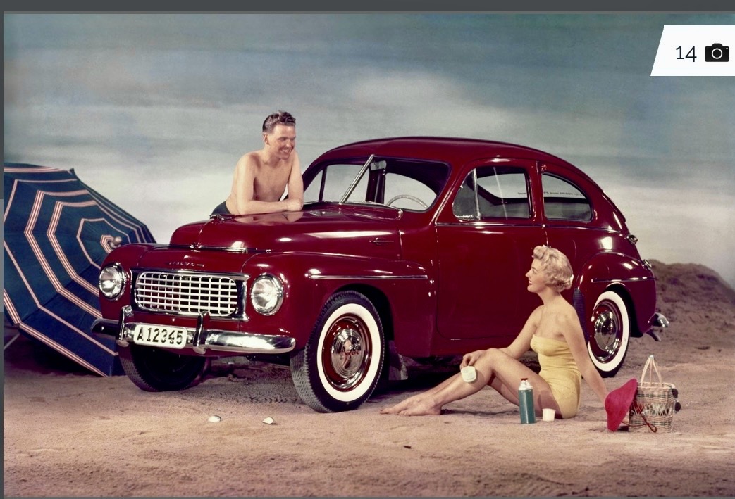 Pubblicità Volvo degli anni Cinquanta: una berlina rossa in spiaggia con una coppia in costume